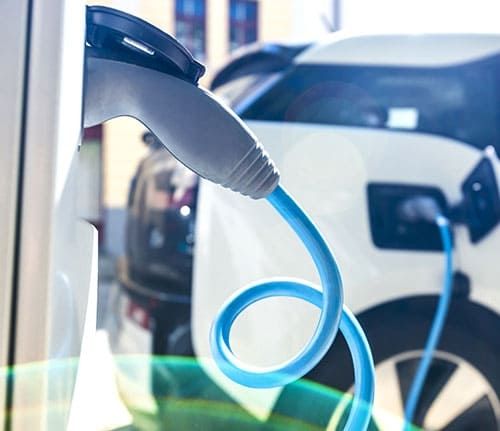 Eine Ladesäule mit E-Autos im Hintergrund