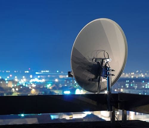 Ein Satelit mit einer Stadt im Hintergrund